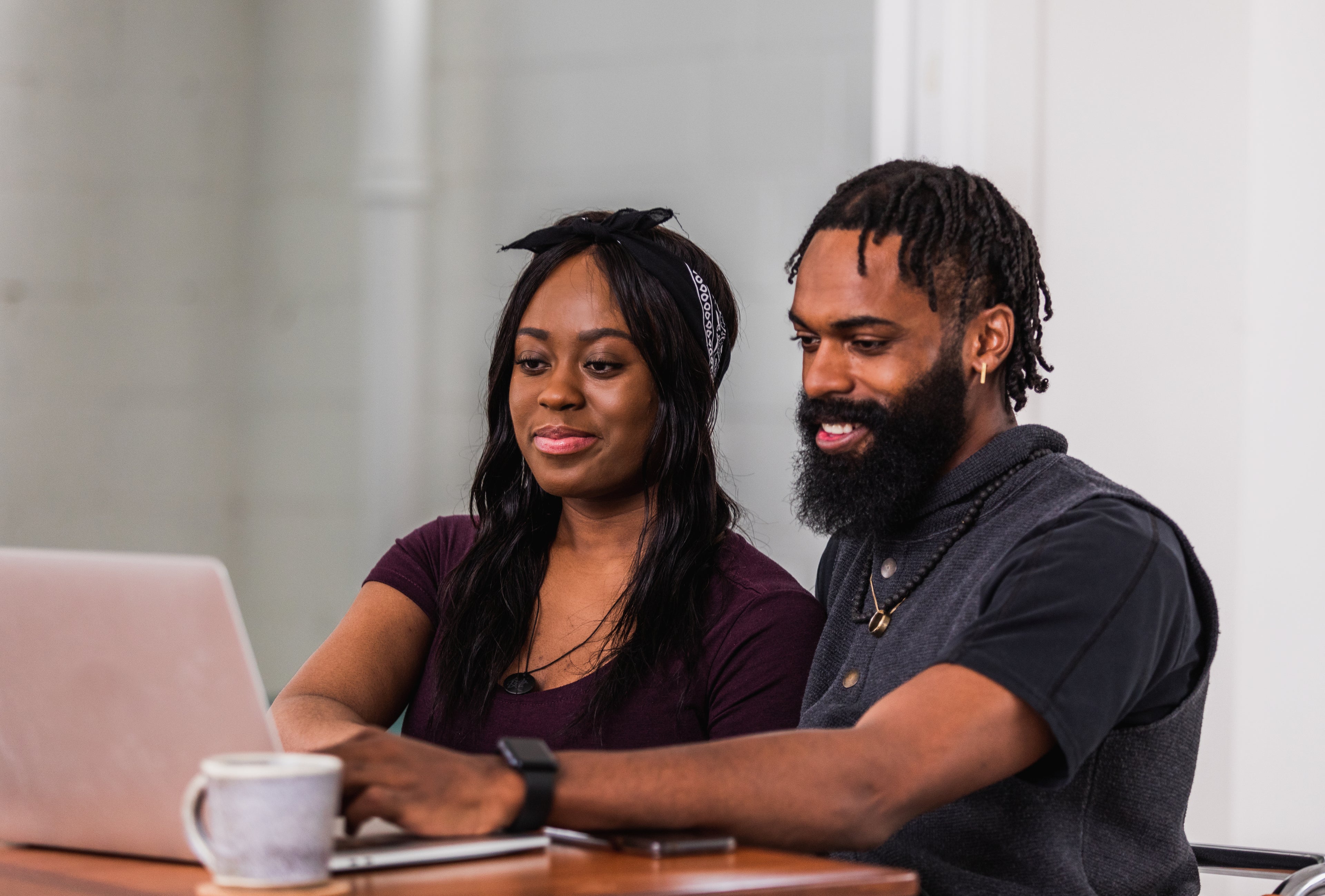 Couple smiling while looking at a laptop